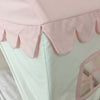 Close-up of a pink scalloped bed skirt on a bed with white bedding.